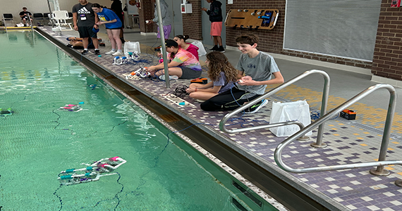 Student in intro into VEX Robotics controling his robot in a pool