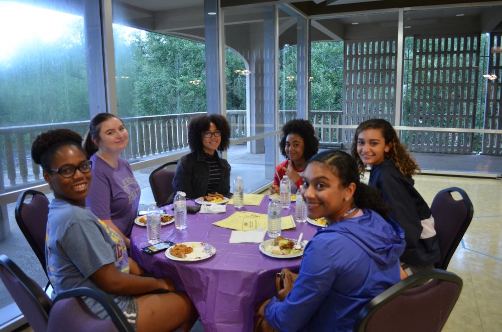 students gathered at table eating dinner