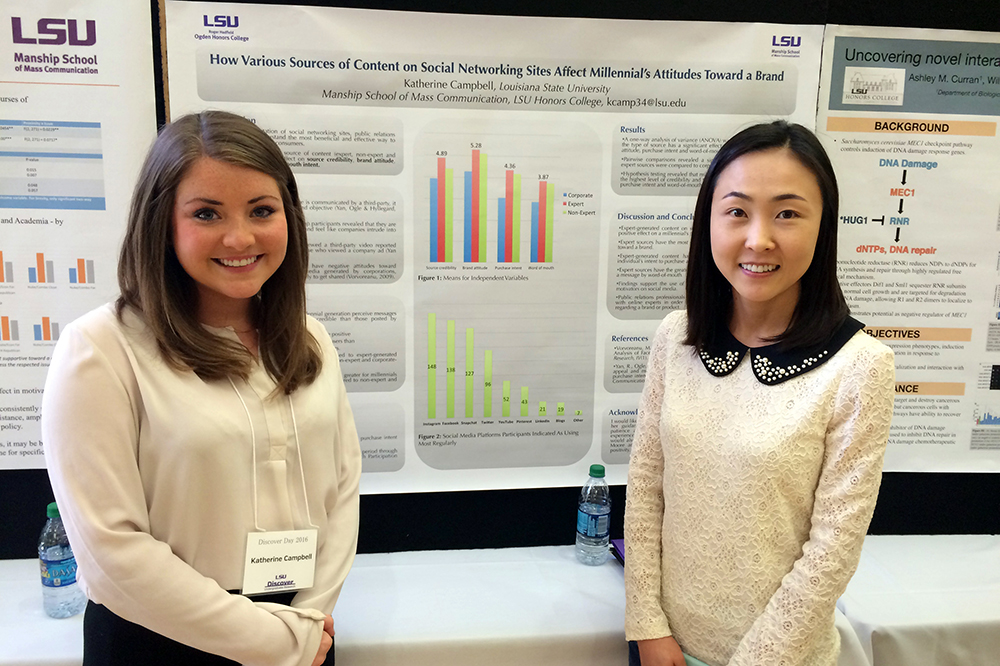 Student and faculty advisor smiling in front of research board